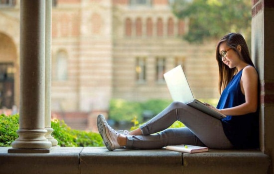 Music student on her laptop on college campus