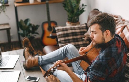 Man playing guitar in his living room