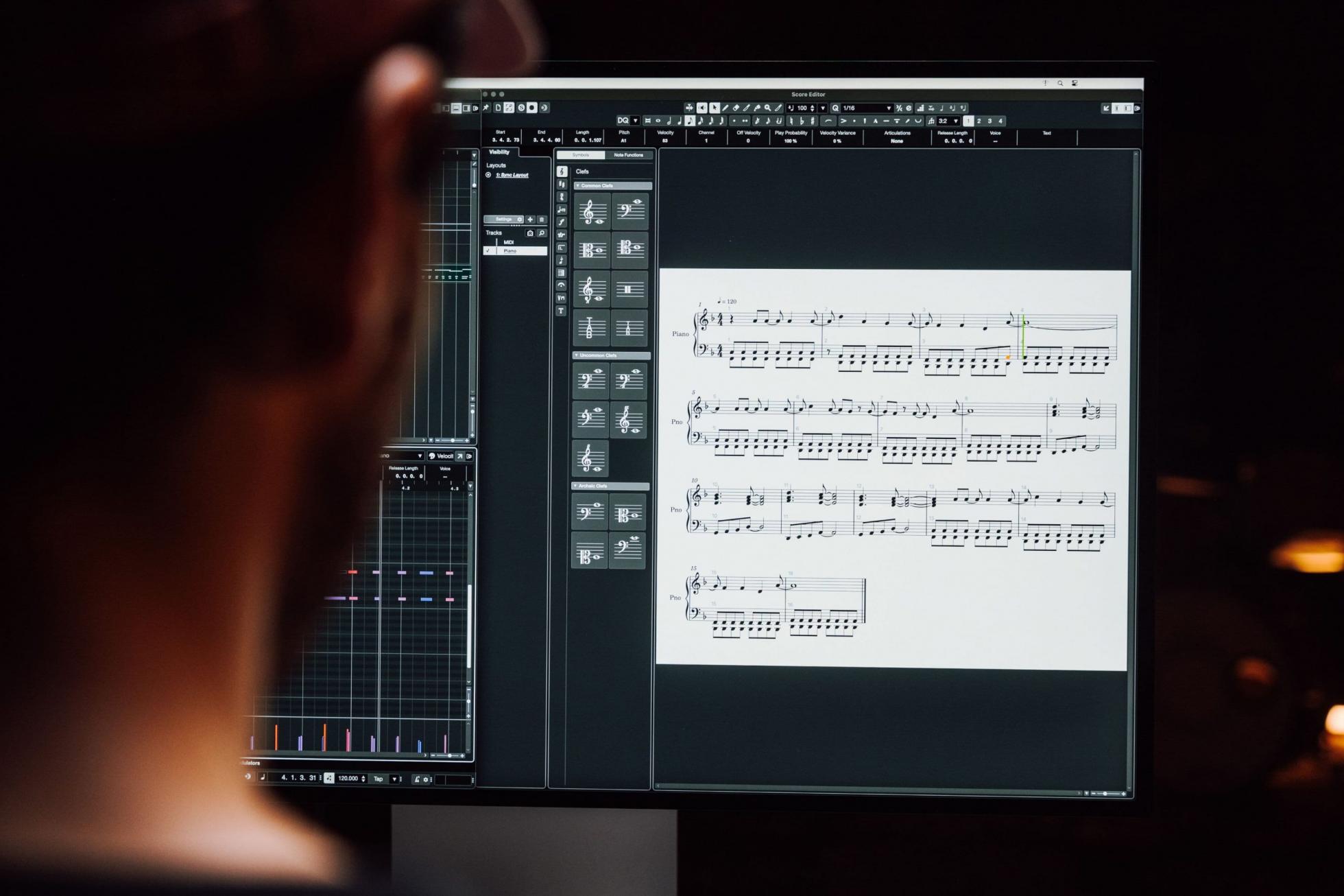 Cubase Score Editor open on a screen, seen from behind a man