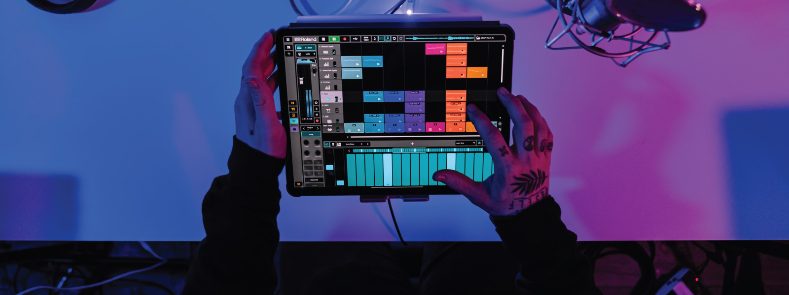 Roland Zenbeats DAW being used on a tablet device held by two tattooed hands